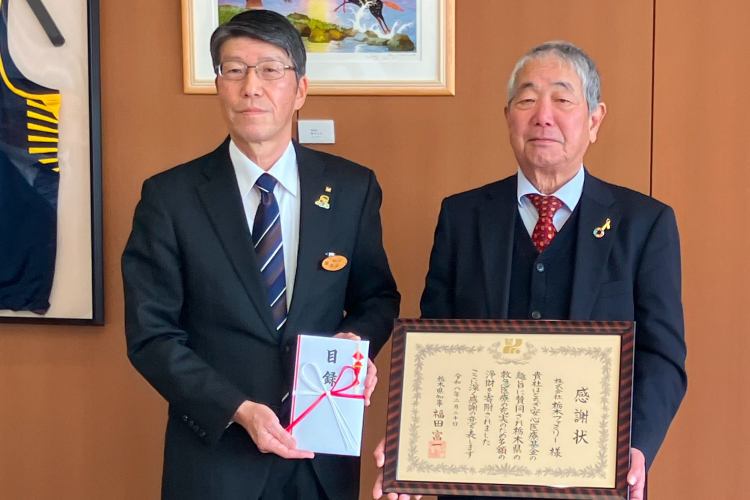 感謝状と目録を持つ2人の男性